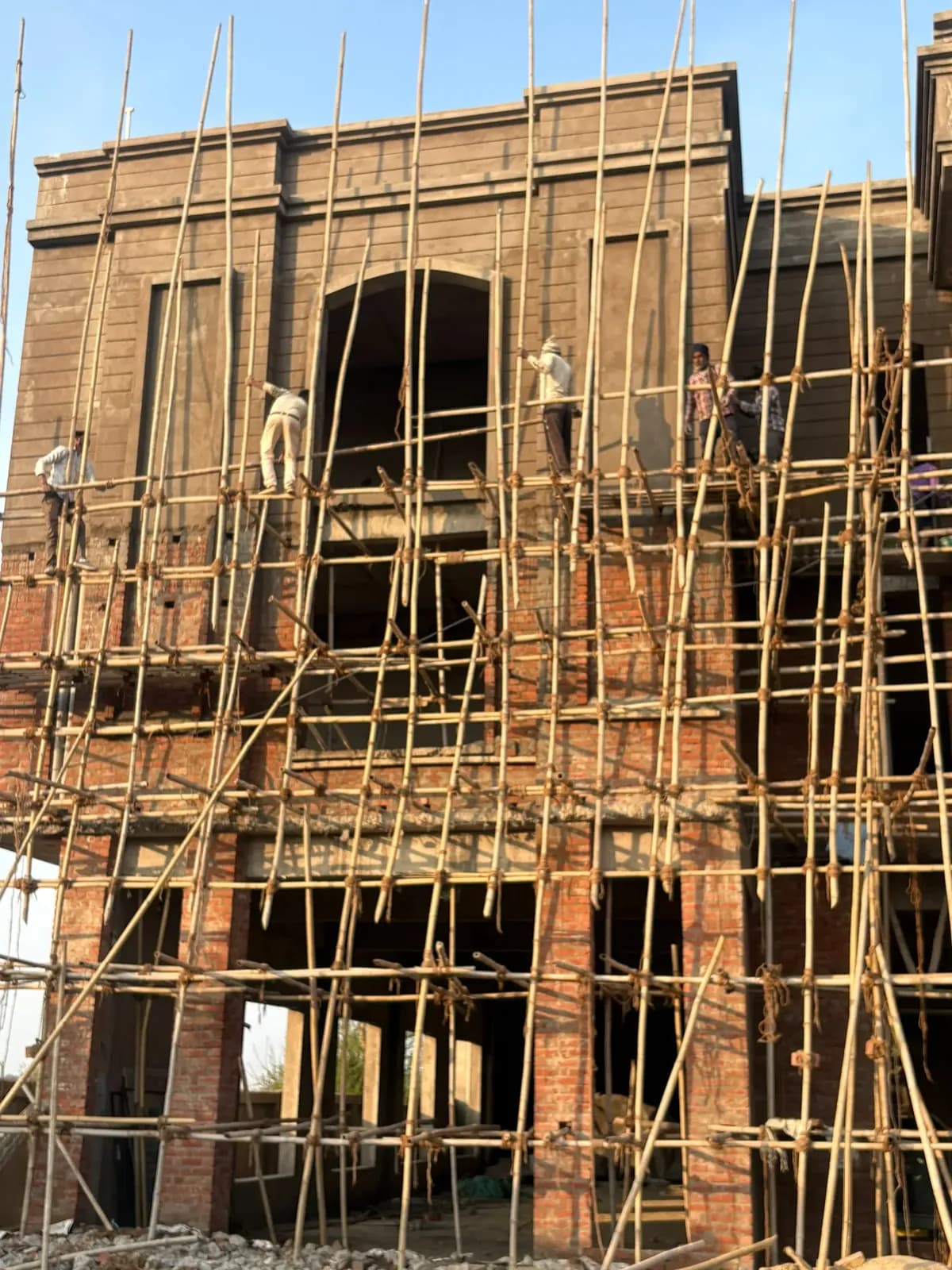 Arched central bay of the classical façade with workers on scaffolding