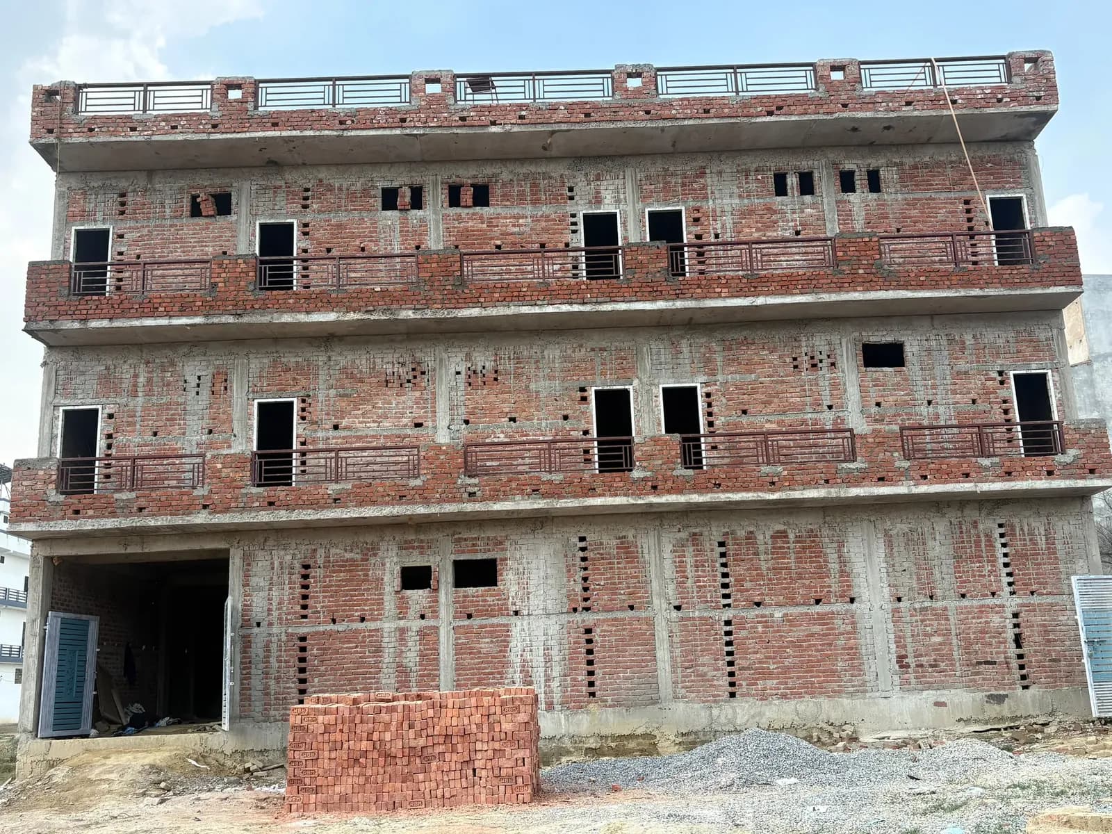 Brick elevation of the four-storey building with balcony railings