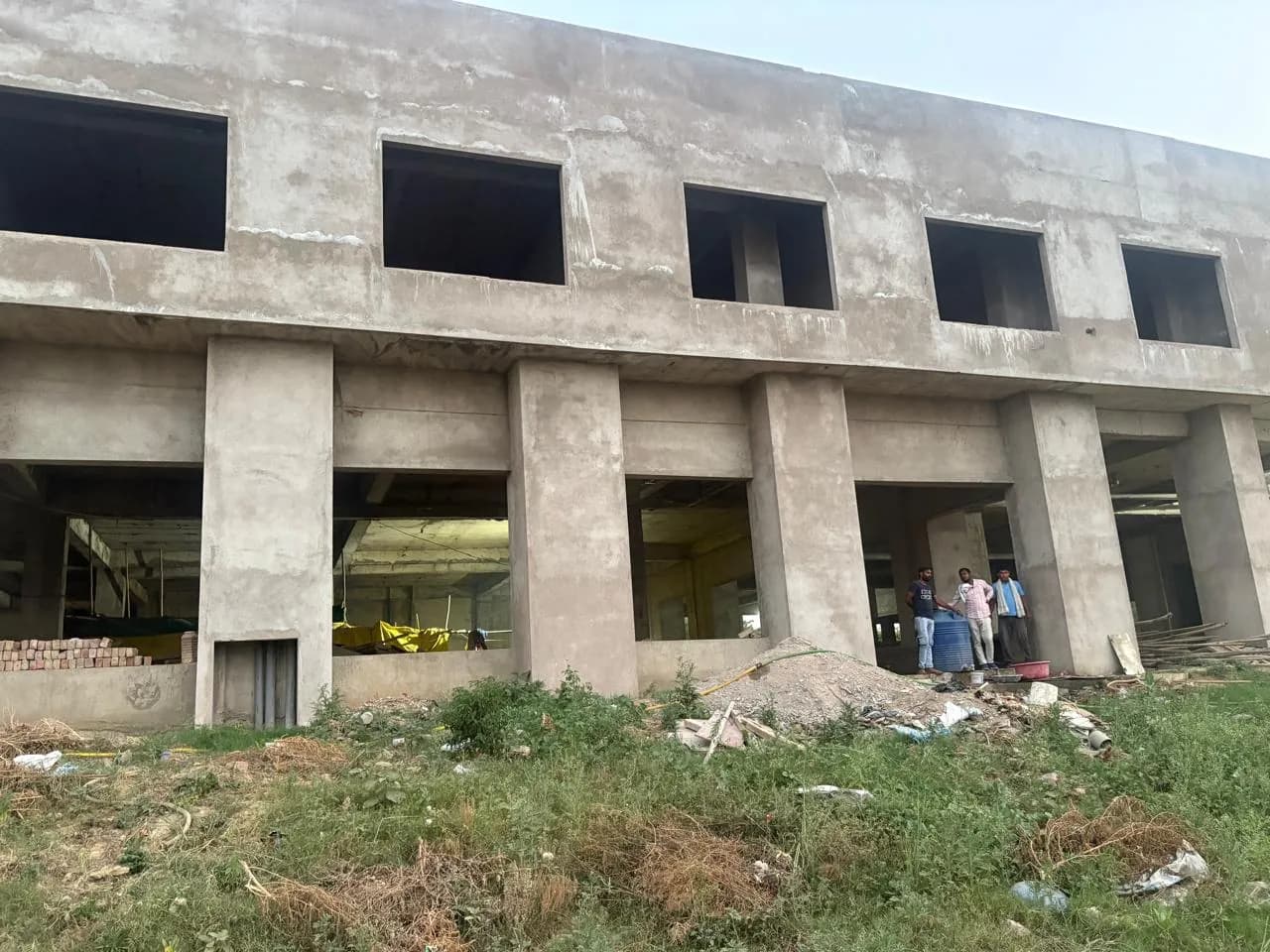 Long concrete elevation with a row of piers and ground-floor openings