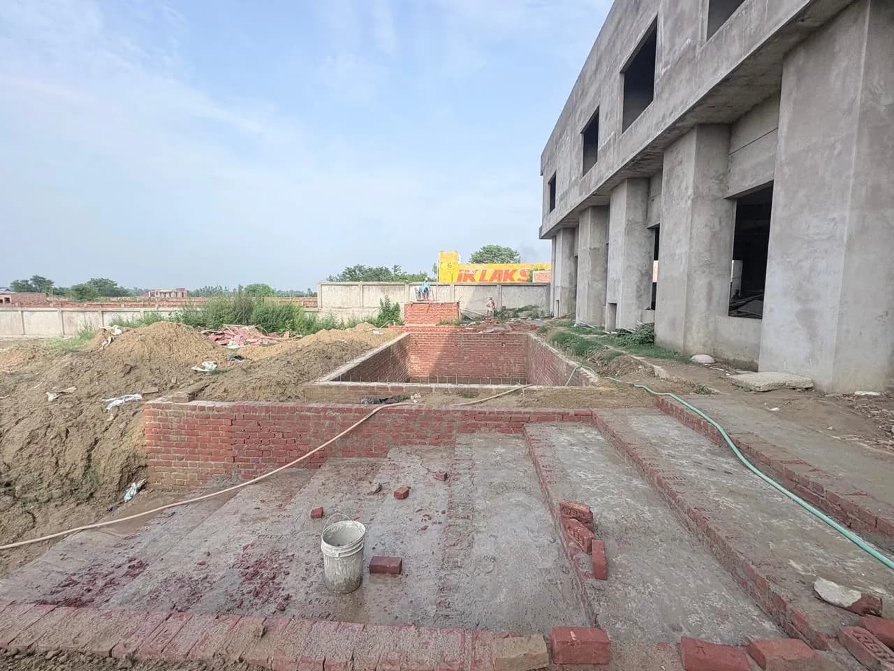 Brick-lined external works beside the concrete building