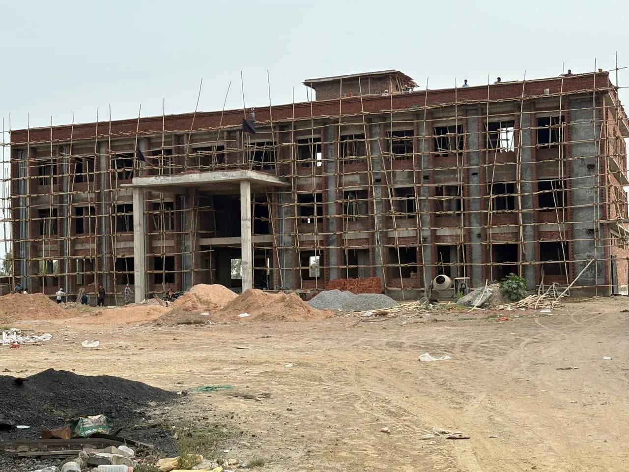 Brick building under full bamboo scaffolding