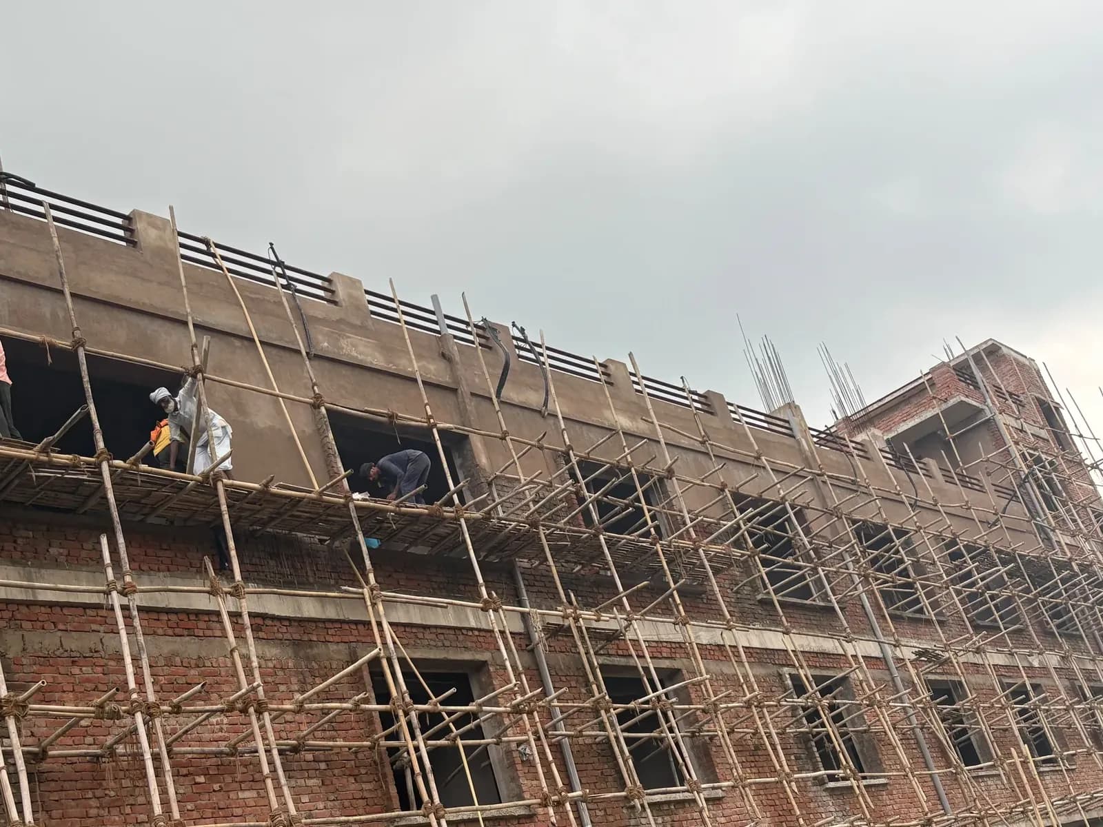 Upper floors in brick with scaffolding and plastering in progress
