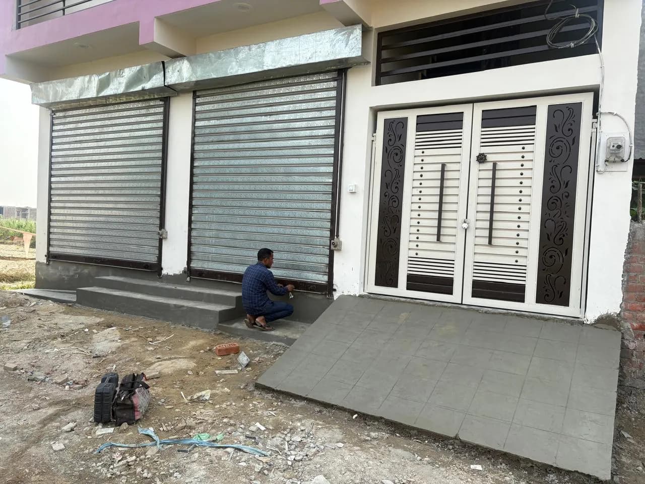Shop shutters and entrance with concrete ramp being finished