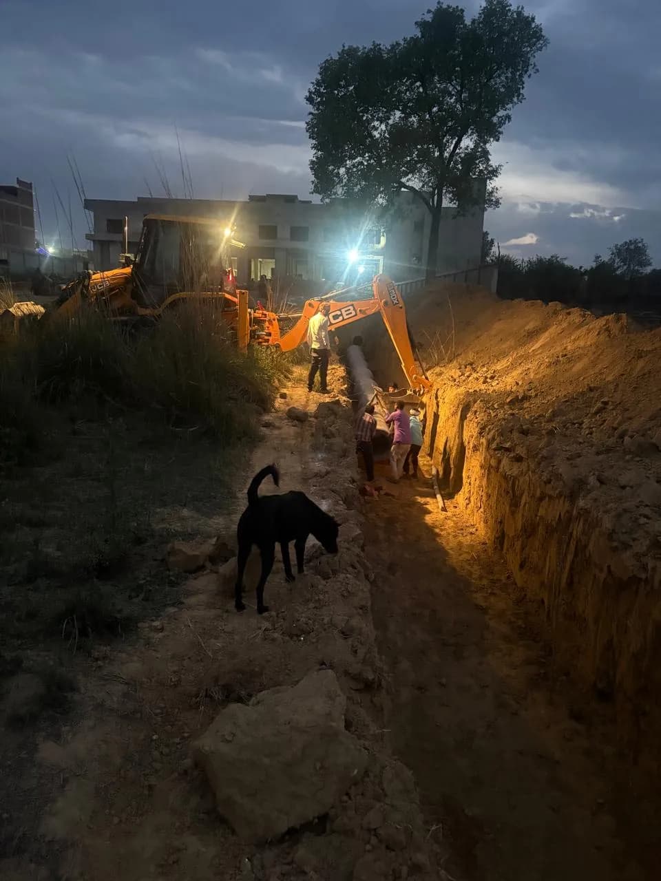Pipe laying continuing at night under site lights