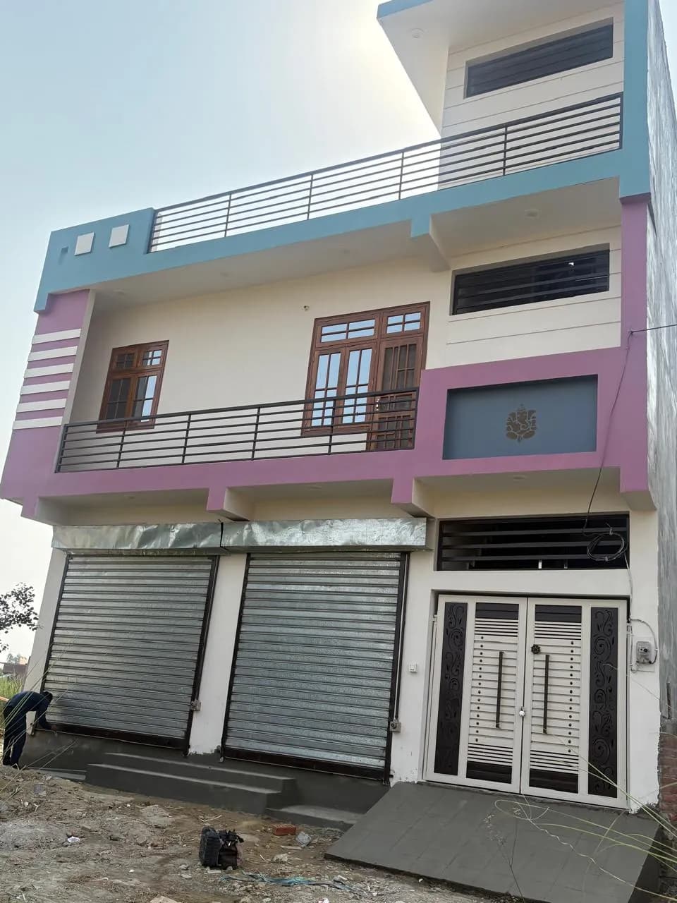 Two-storey building with shop shutters and a colour-accented façade